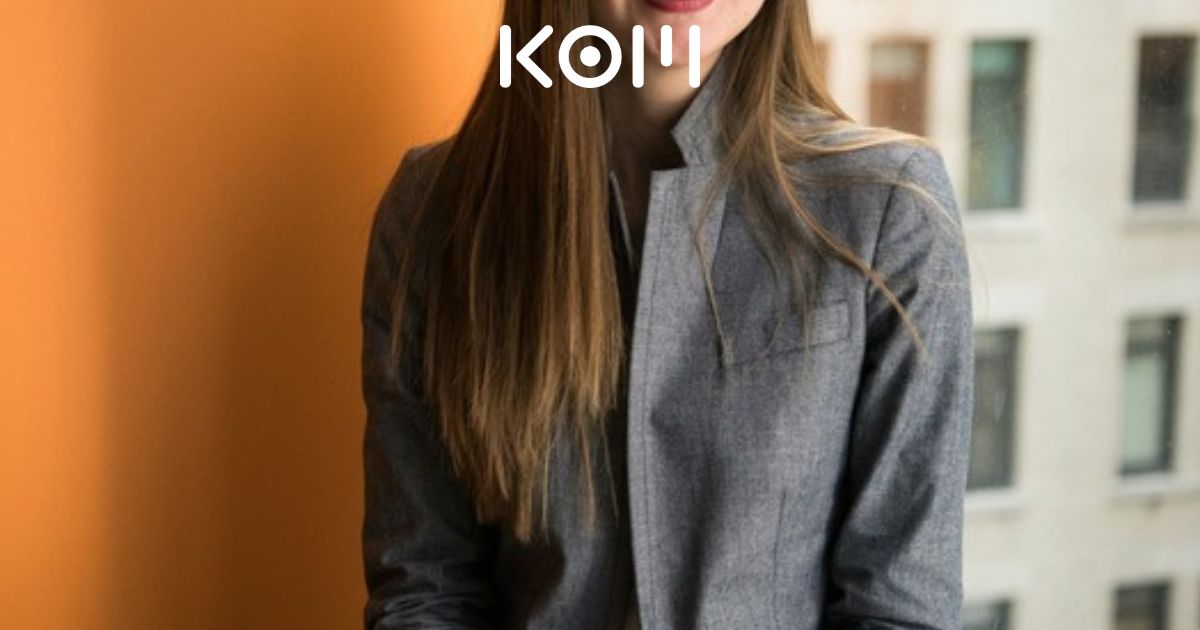 Profesional joven con laptop y sonrisa confiada en oficina moderna para Asistente Administrativo Comercial Part Time remoto en KOM Agencia Digital.