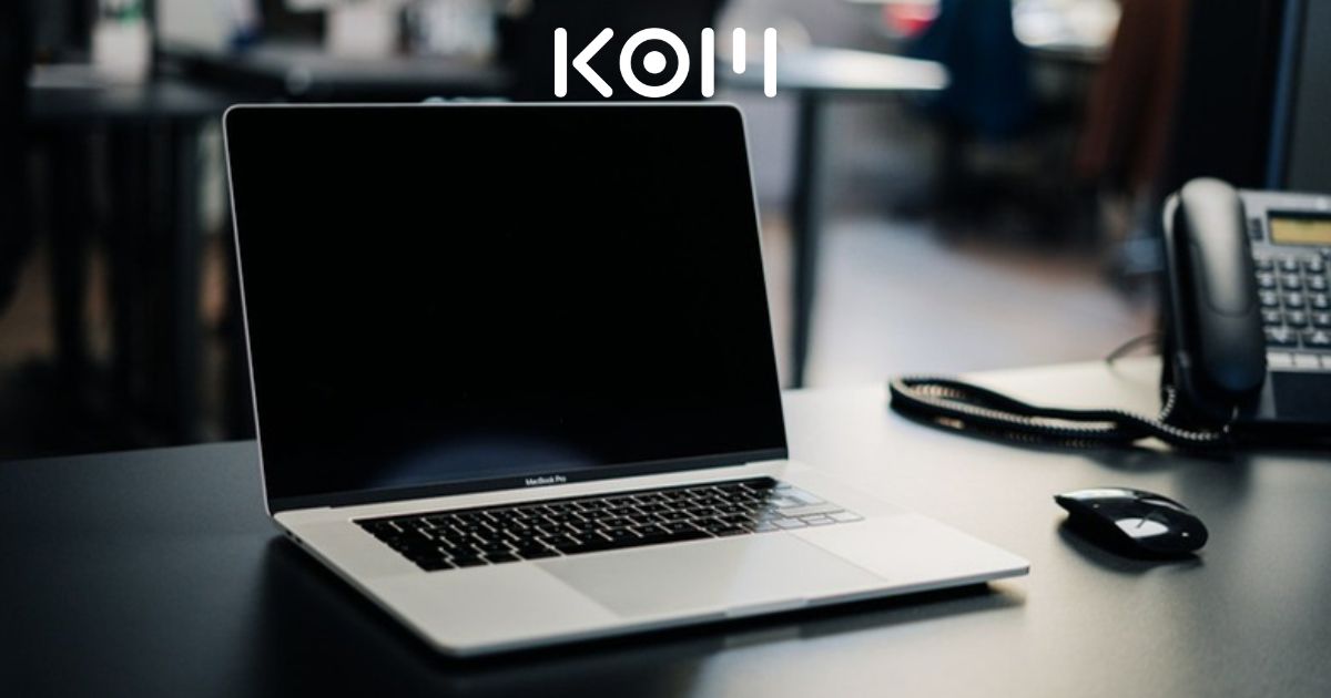 Escritorio con laptop, teléfono y mouse en oficina moderna para puesto de Soporte Técnico WordPress Nivel 1 Mesa de Ayuda 24/7 en KOM Agencia Digital.