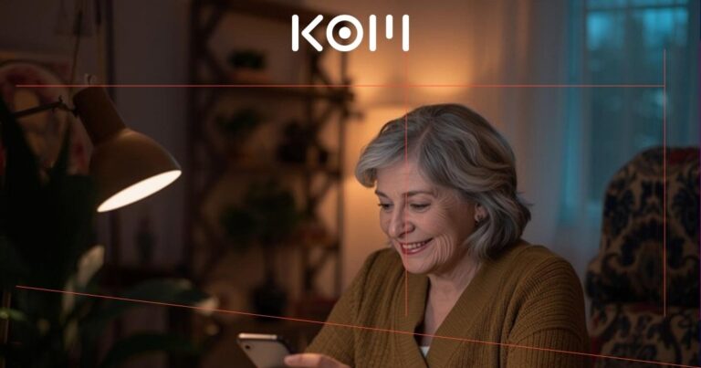 Mujer mayor sonriente realizando pago online con smartphone y tarjeta de crédito en ambiente cálido del hogar - KOM