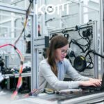 Persona trabajando con tecnología industrial en planta de producción - KOM Agencia Digital