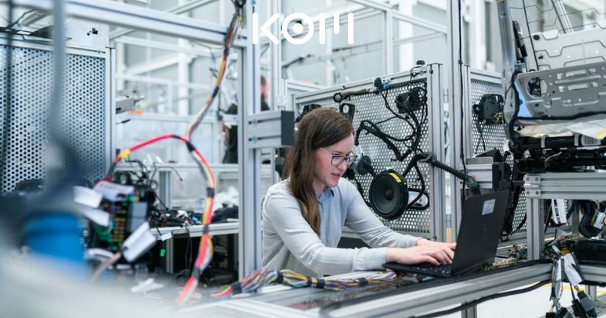 Persona trabajando con tecnología industrial en planta de producción - KOM Agencia Digital