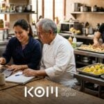 Dueña de un catering y su chef revisan una cotización en la laptop mientras usan IA para eventos y preparan bocaditos