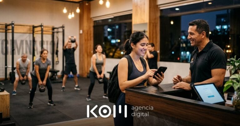 Entrenador conversa con una socia que reserva su clase desde el celular en la recepción, un uso práctico de IA para gimnasios