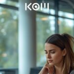 Joven profesional analizando y comparando información en laptop en espacio de coworking con luz natural - KOM